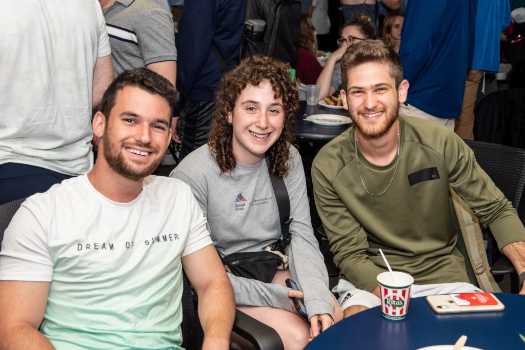 Three students sit at a table.