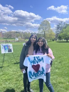 Two students standing together outside holding a t-shirt that they spray painted in honor of Israel Independence Day